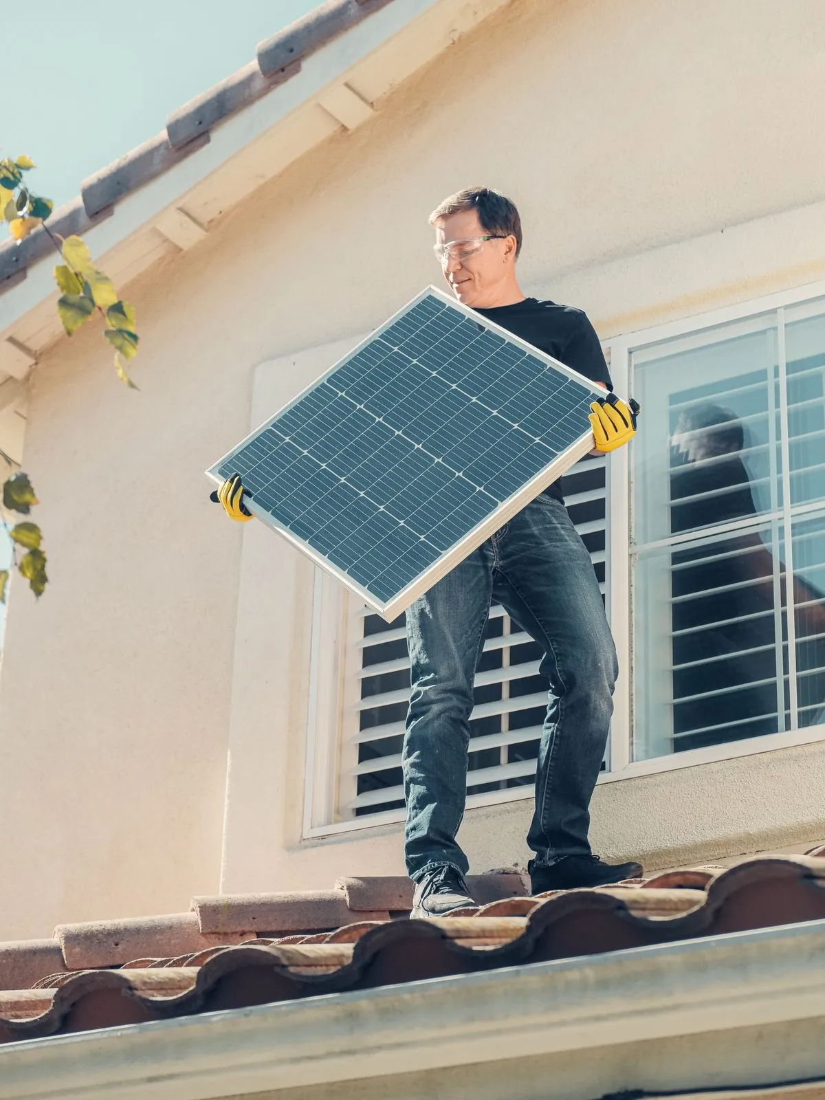 Worker carrying a photovoltaic panel